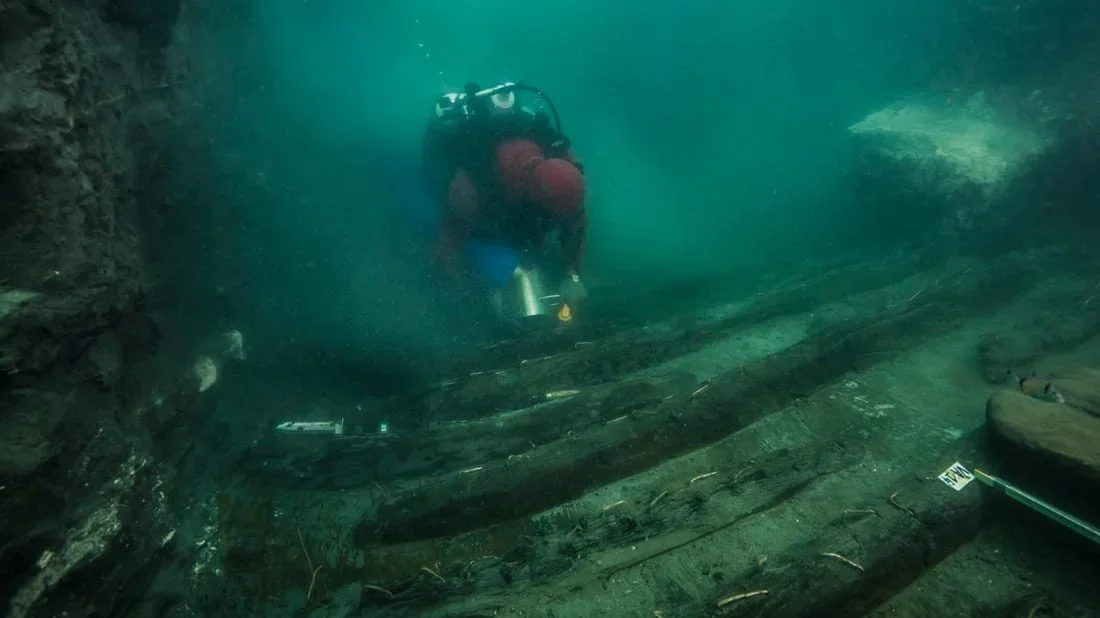 An archaeologist measuring the feet and other fragments of a colossal statue after preliminary cleaning on site at Thonis-Heracleion in the Bay of Aboukir.