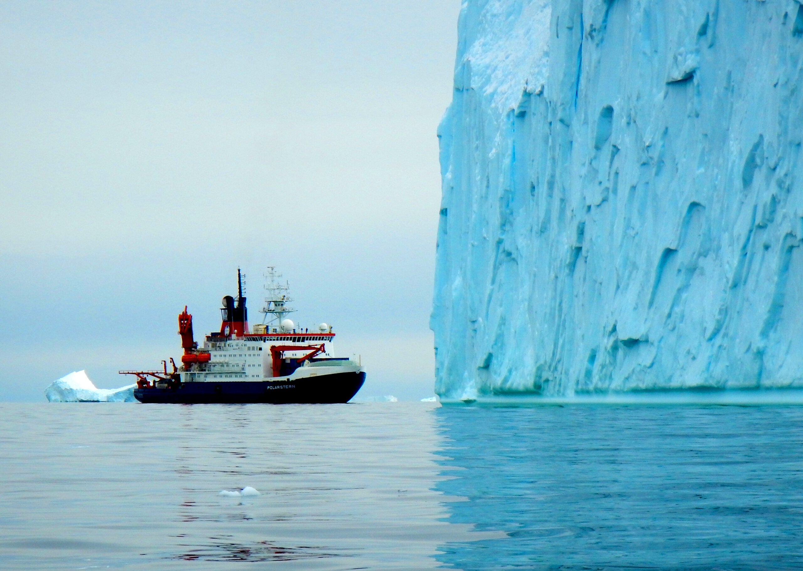 The RV Polarstern in front of a huge iceberg in Pine Island Bay. 