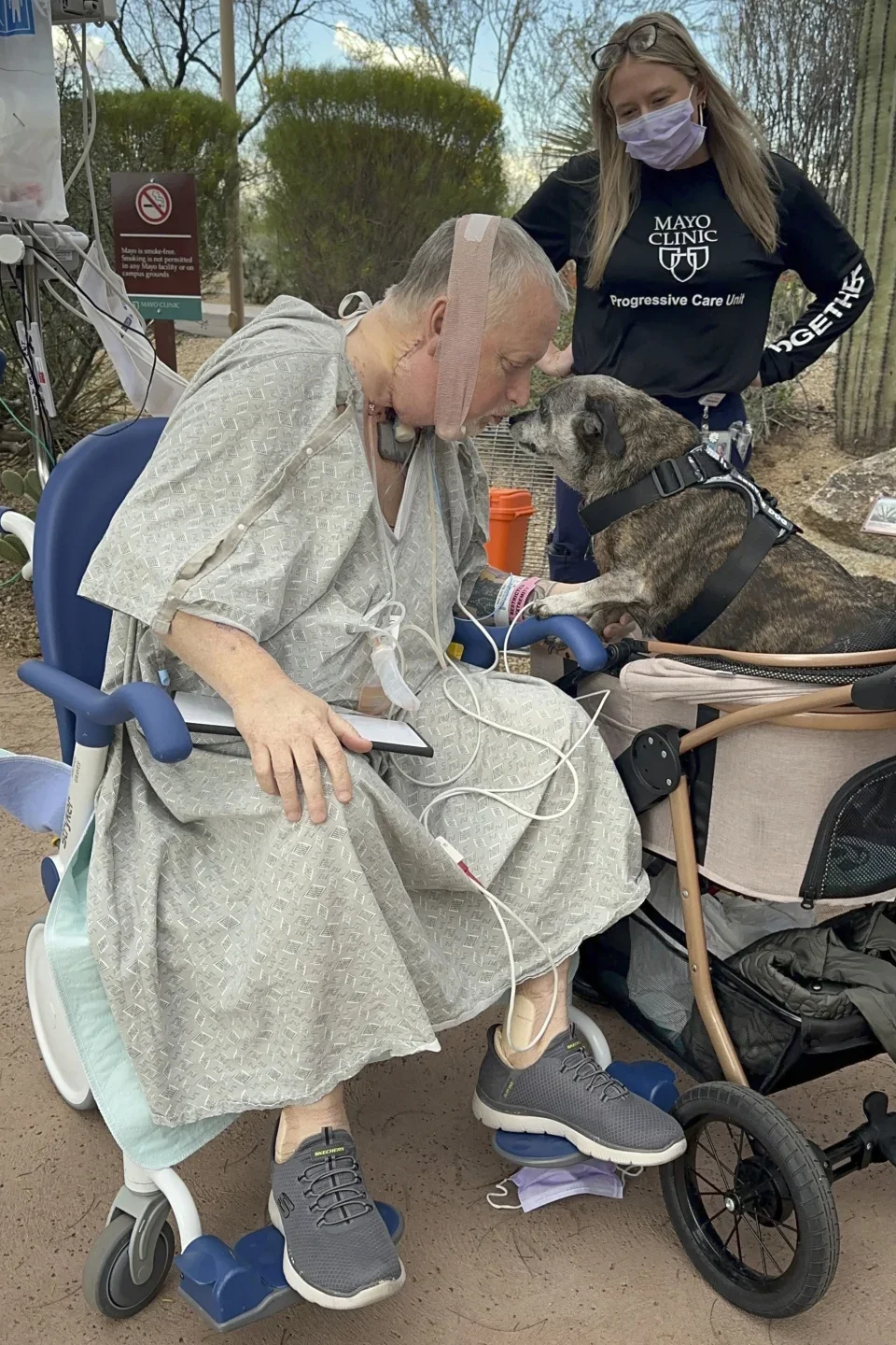 Marty Kedian greets his dog, Baxter, on his first trip outside the Mayo Clinic Hospital after his surgery
