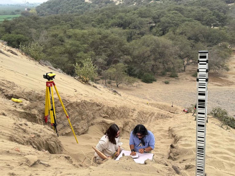 A team of archaeologists work on what appear to be parts of a 4,000-year-old ceremonial temple buried in a sand dune of northern Peru, in Lambayeque, Peru