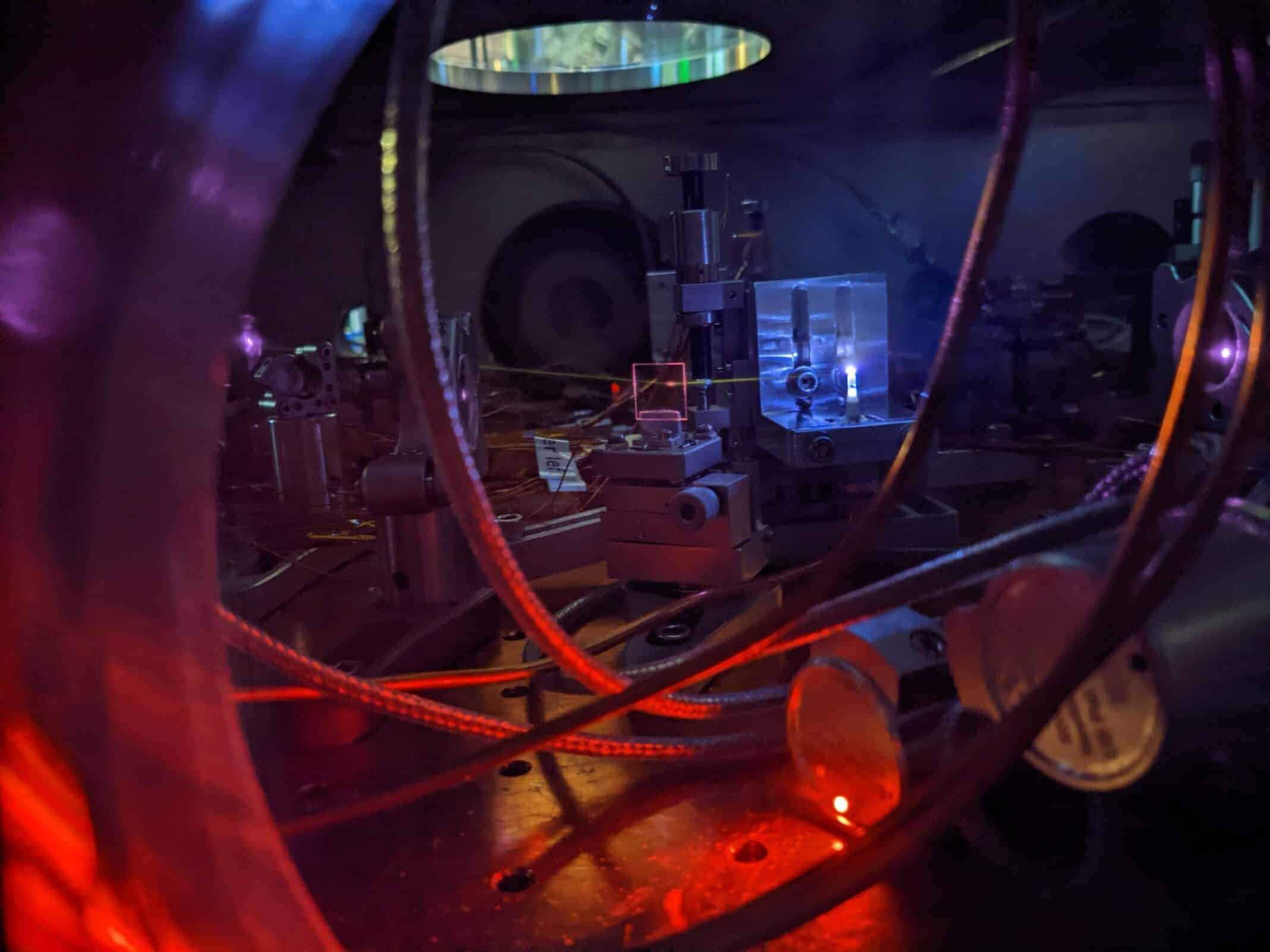 A powerful laser shines into a jet of gas, creating a bright plasma and generating ultraviolet light. The light leaves a visible white line as it interacts with leftover gas in the vacuum chamber. This process helps scientists precisely measure the energy needed to excite the thorium-229 nucleus, which is the core of a future nuclear clock. 