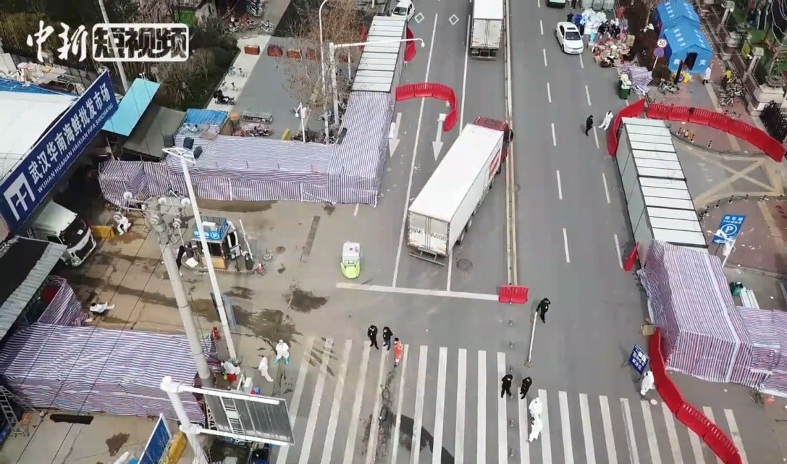 Professional sterilization teams can be seen outside the main entrance of the Huanan Seafood Wholesale Market in Wuhan, China in March 2020, shortly after its closure.