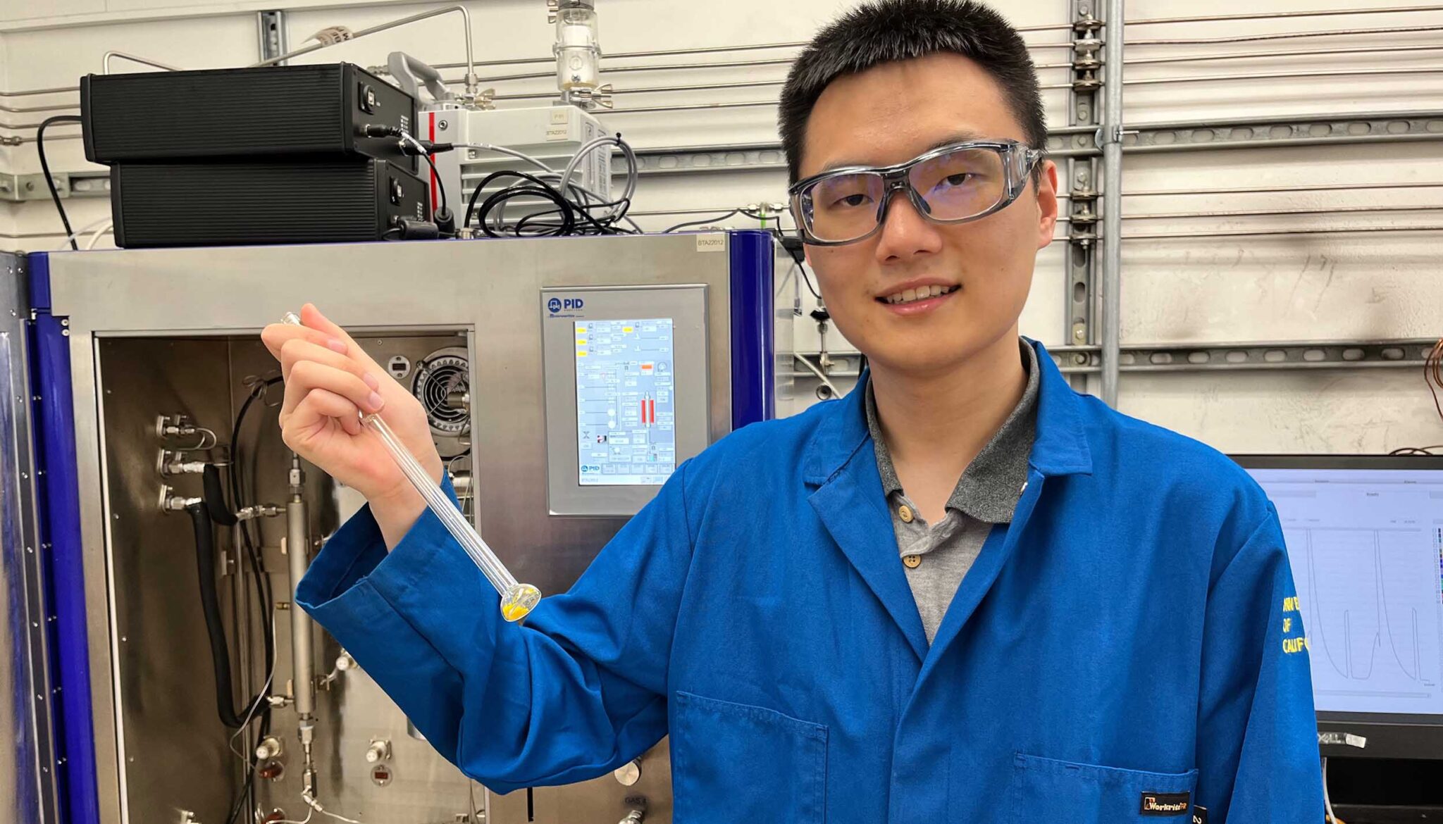 UC Berkeley graduate student Zihui Zhou with a 100 milligram test sample of COF-999. The sample was placed in the analyzer behind Zhou to measure carbon dioxide adsorption from an air mixture similar to that of ambient air.