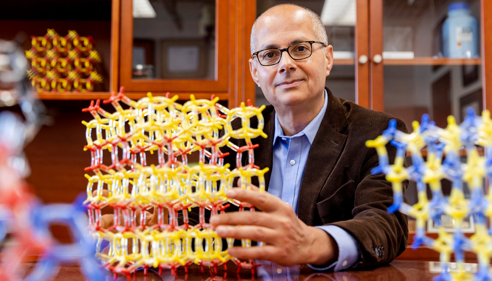Omar Yaghi with molecular models of some of his porous structures, called metal-organic frameworks, or MOFs. COFs have similar internal structures, but are held together by strong covalent bonds instead of by metal atoms.