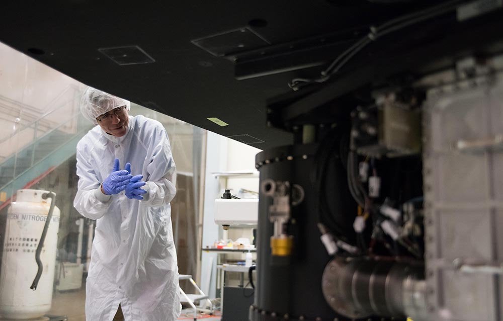 Chris Martin, the principal investigator of the Keck Cosmic Web Imager, inspects the instrument in a clean room at Caltech.