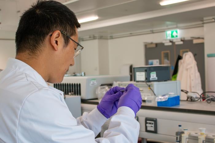 Professor Zhugen Yang folds a paper sensor in a laboratory at Cranfield University