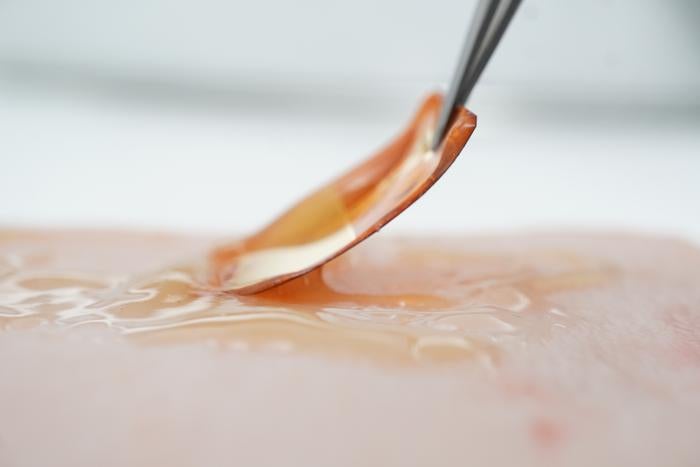 Flexible electroceutical patch being applied to skin. 