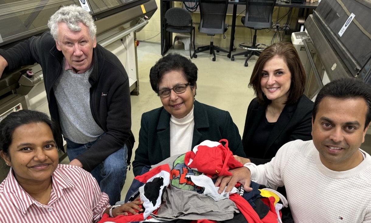 The research team with a pile of discarded clothes that could be used in their concrete.