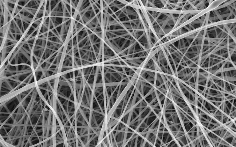 The team used a scanning electron microscope, scanning the mat with a focused beam of electrons and creating an image based on the pattern of electrons that are deflected or knocked-off. Each individual strand is too narrow to be clearly captured by any form of visible light camera or microscope.