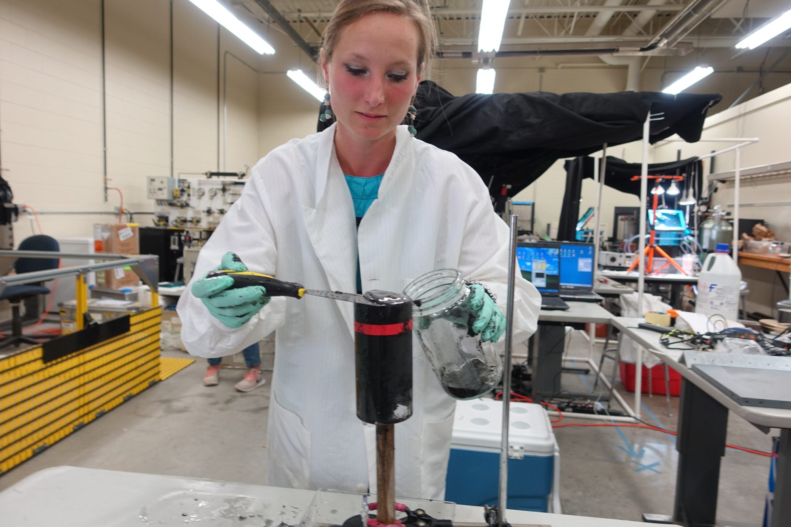 Geomicrobiologist Judith Klatt, formerly a postdoctoral researcher in Greg Dick's U-M laboratory and now at the Max Planck Institute for Marine Microbiology, scrapes a microbial mat from the top of a sediment core collected at the Middle Island Sinkhole in Lake Huron.