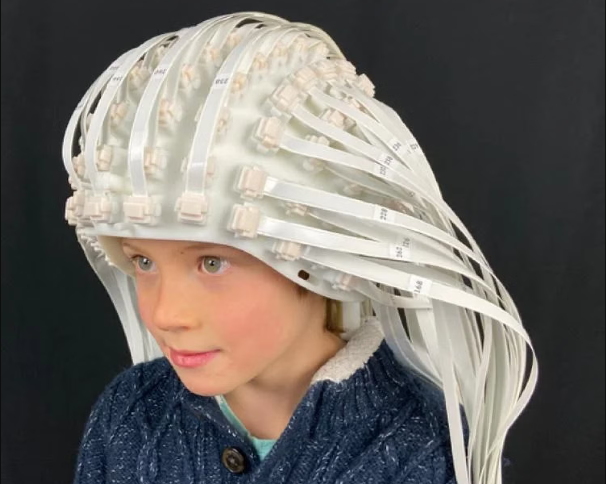 A child wears a helmet manufactured by FieldLine Inc. made up of more than 100 OPM sensors. 