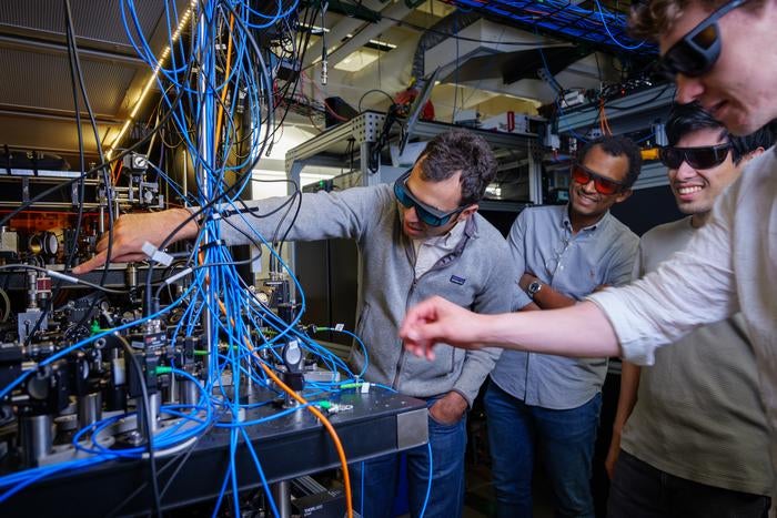 From left to right, Adam Kaufman, Nelson Darkwah Oppong, Alec Cao and Theo Lukin Yelin inspect an atomic optical clock at JILA.

