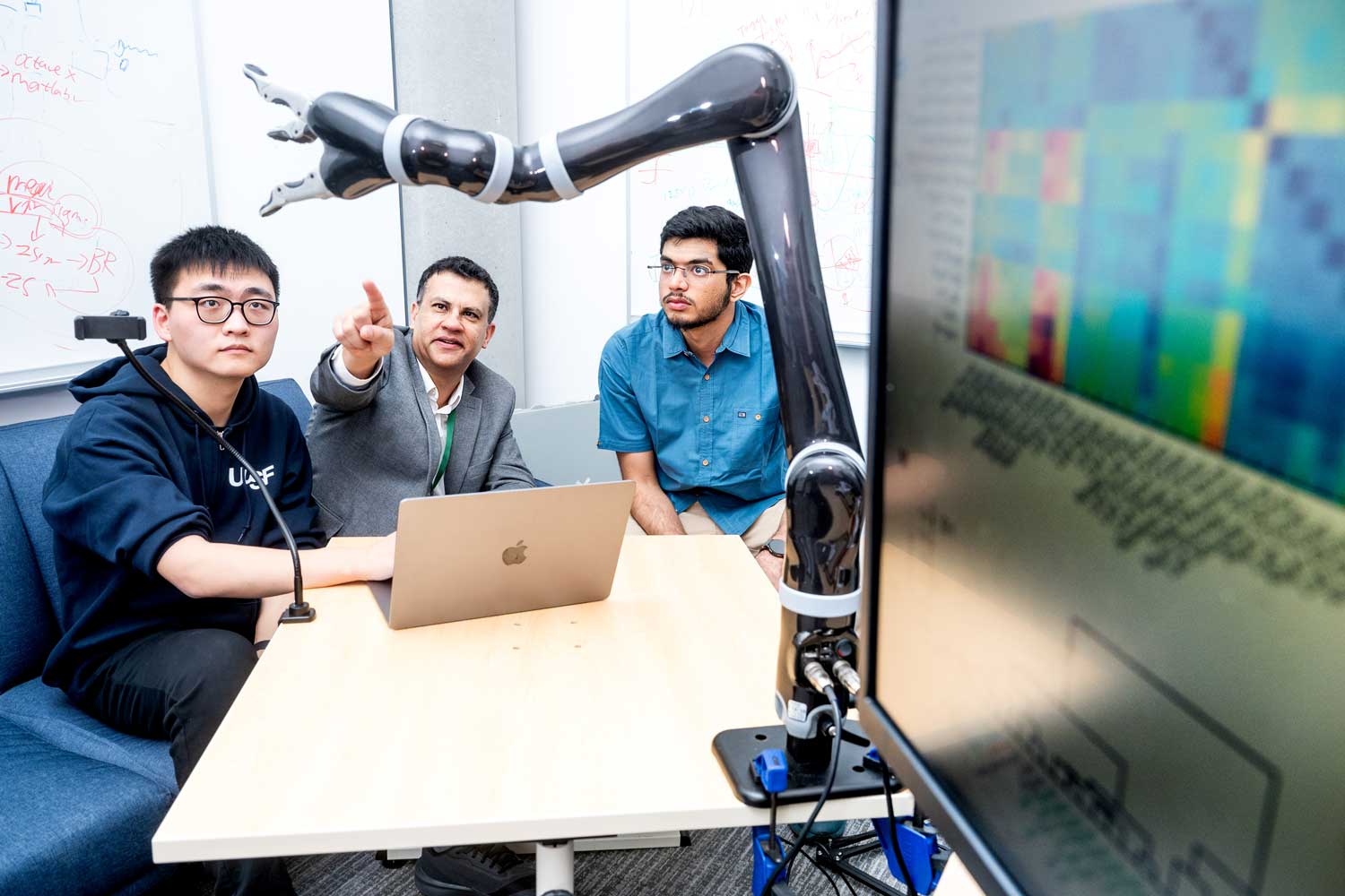 Karunesh Ganguly, M.D., Ph.D. (center), works in his lab with graduate students Runfeng Miao (left) and Harsha Peesapati (right).