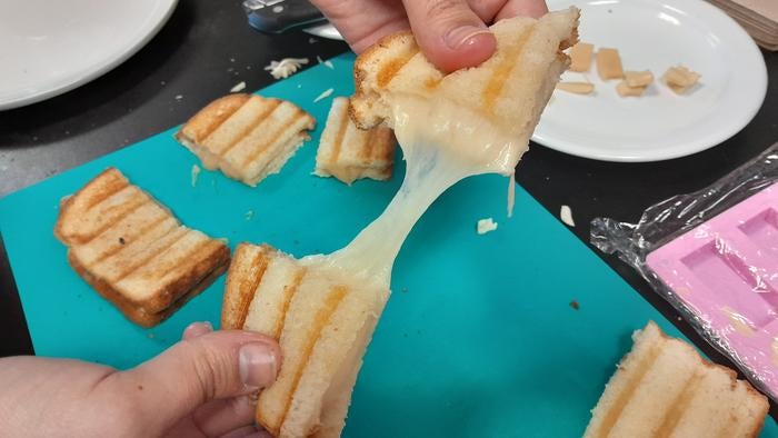 Researcher Alejandro Marangoni demonstrates the stretchy properties of his team’s plant-based cheese analog.