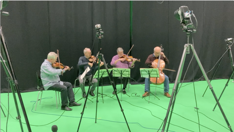 he Coull Quartet playing with motion-capture markers on their string instruments. They are surrounded by motion-capture cameras.