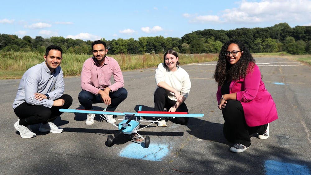 Aimy Wissa (right) next to RC plane on Forrestal Campus runway.