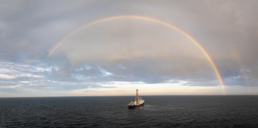 A drone captures a beautiful image of the JOIDES Resolution surrounded by a rainbow.