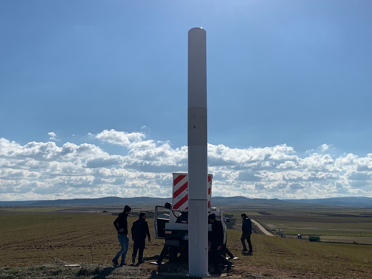 Installation crew installing the NEOM Atlantis model bladeless turbine in a field.