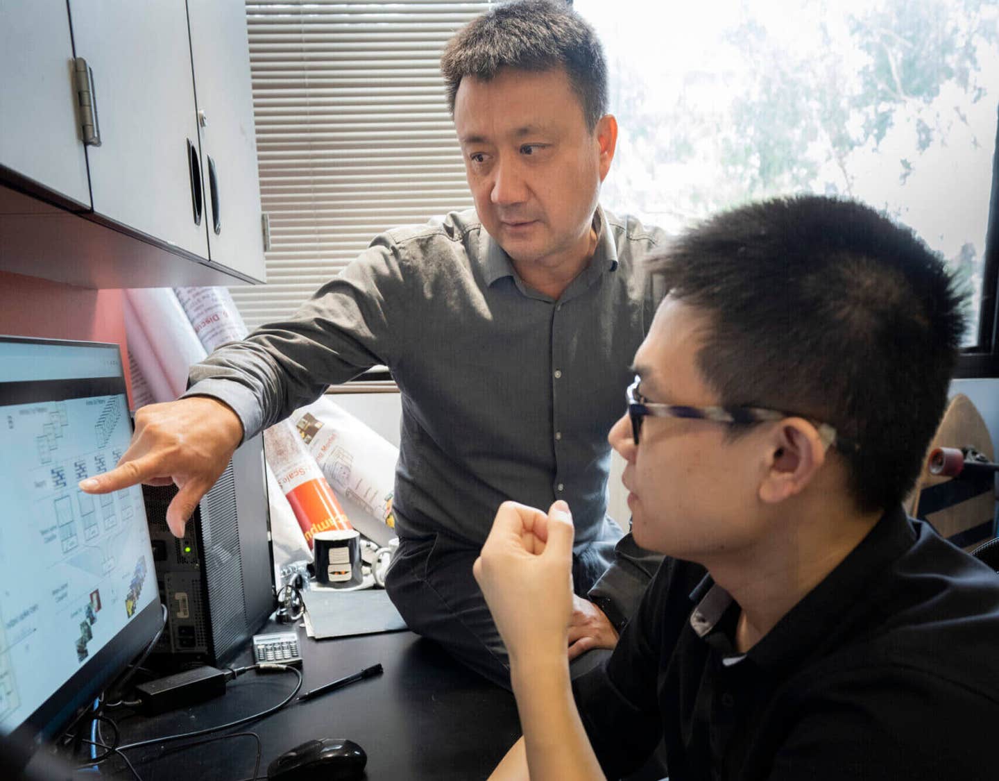 Associate professor Dong Song (L) and first author Xiwei She (R) discuss their machine learning model.