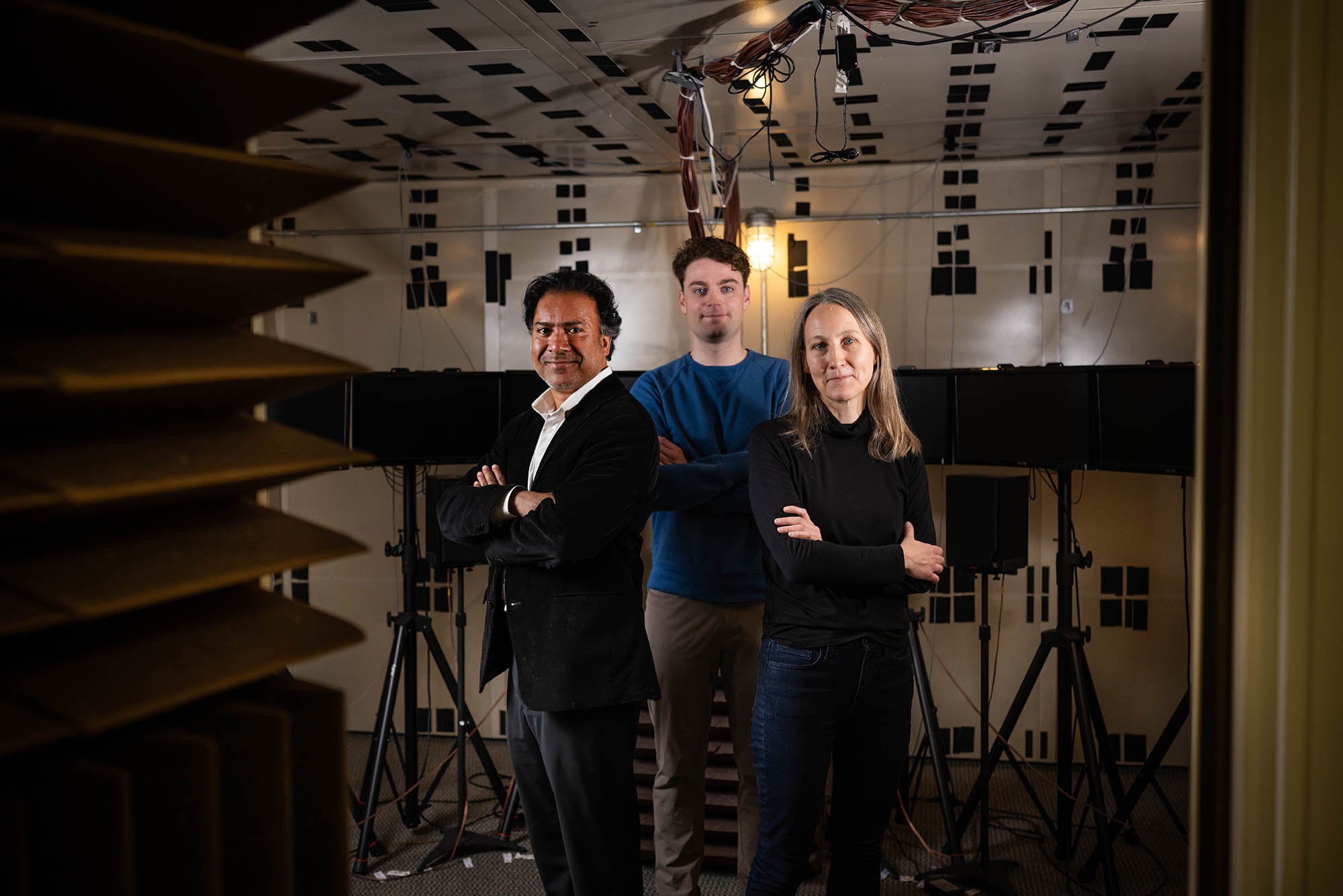 In a BU lab, researchers (from left) Kamal Sen, Alexander D. Boyd (ENG’23,’26), and Virginia Best tested a brain-inspired algorithm’s ability to help hearing aid users separate sounds in noisy places.