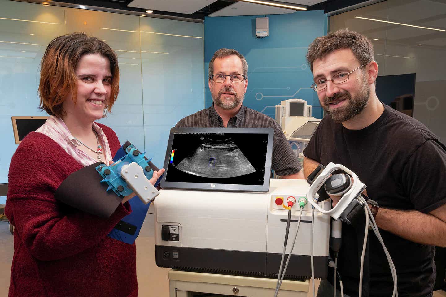 Pictured (left to right): GE Research’s Victoria Cotero, Senior Scientist in Biosciences; Jeffrey Ashe, a senior electrical engineer; and Christopher Puleo, a senior biomedical engineer, around a prototype of the Research Lab’s ultrasound modulation device at GE’s research campus in Niskayuna, NY.