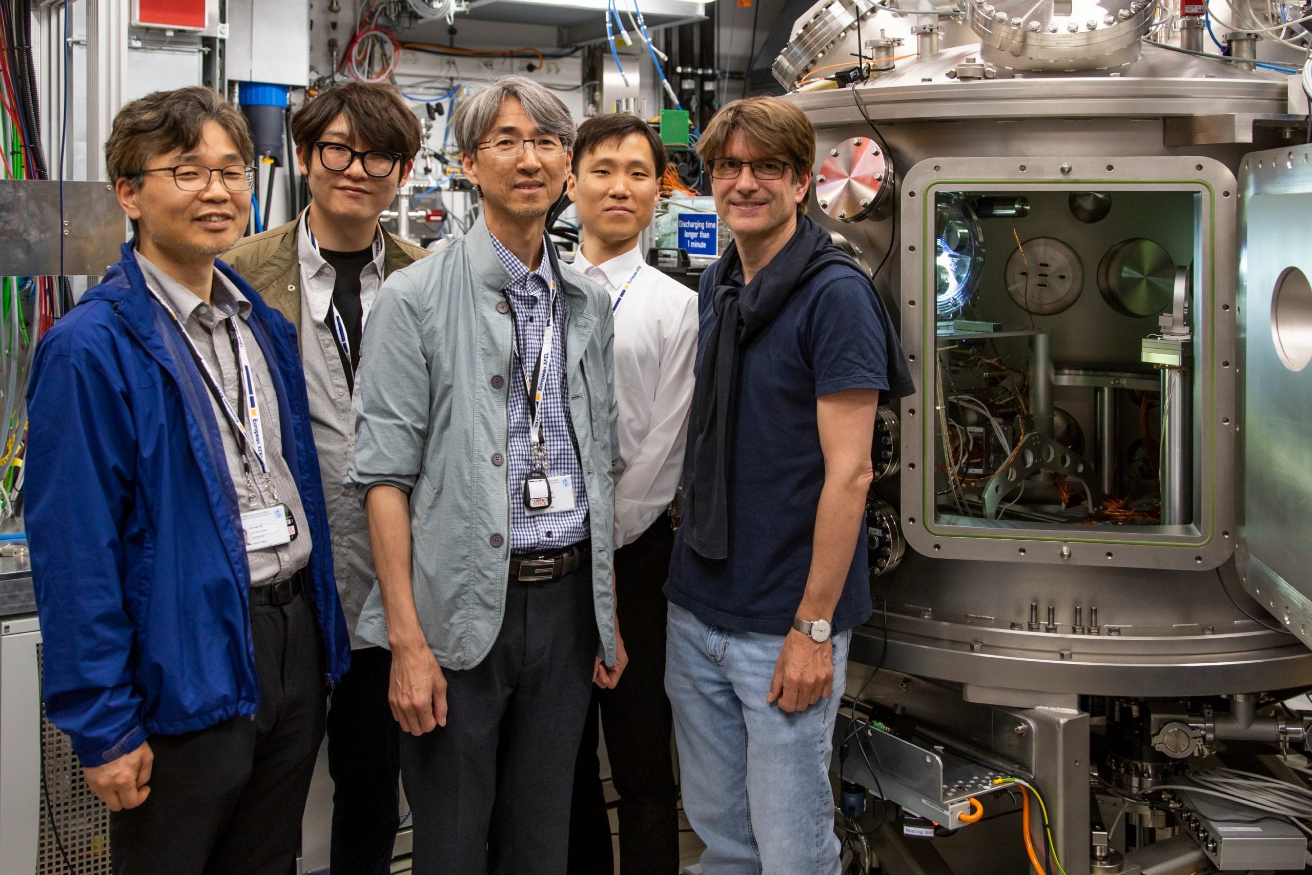 Scientists from KRISS and DESY, including Cornelius Strohm, stand beside the IC2 chamber inside the High Energy Density (HED) experiment hutch.