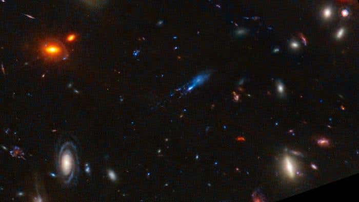 Galaxy Y1 shines thanks to dust grains heated by newly-formed stars. Image from the James Webb telescope.