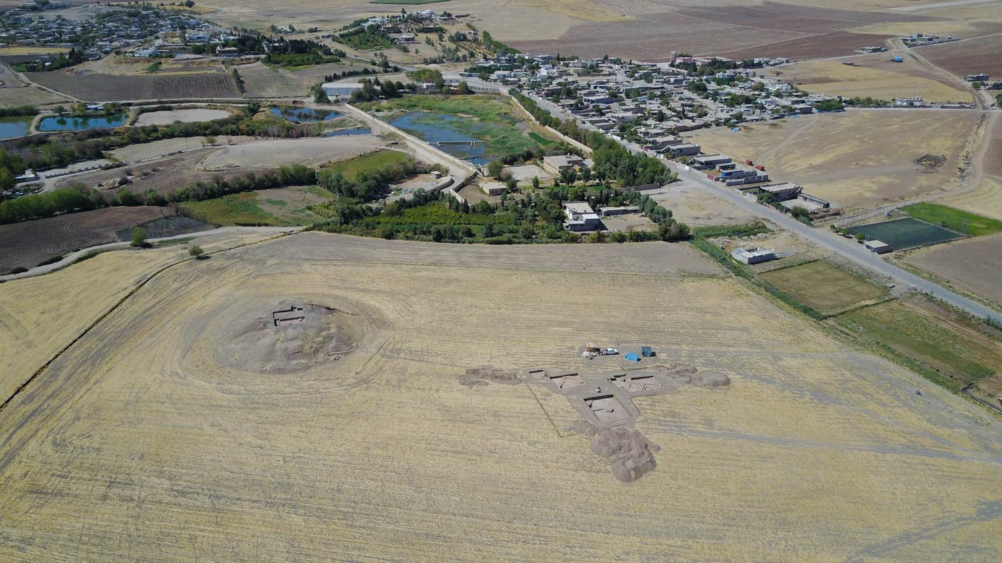 Excavation site Gird-î Kazhaw in the foreground; the modern village of Bestansur in the background.