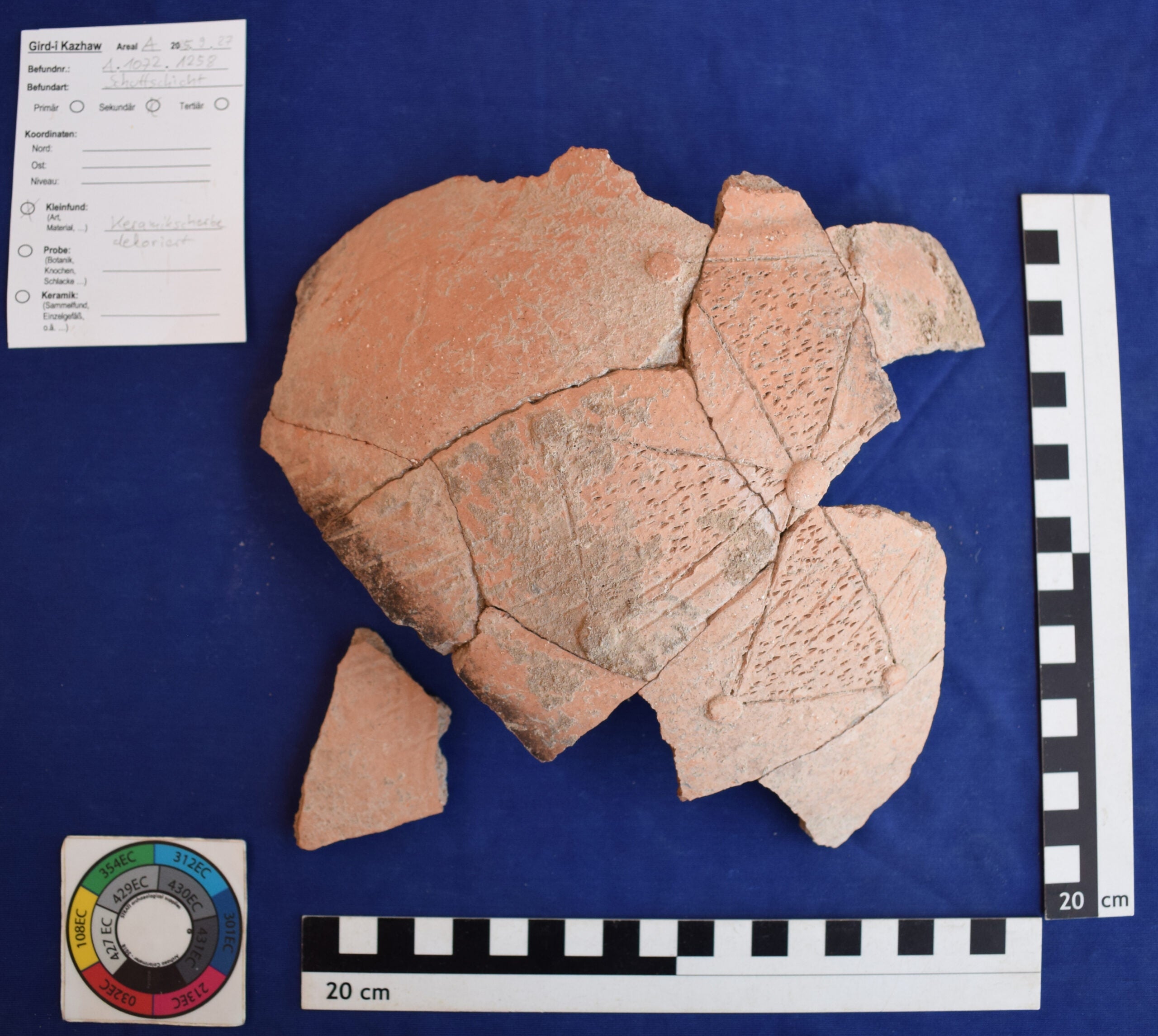 Pottery fragment with carved, cross-shaped decoration.