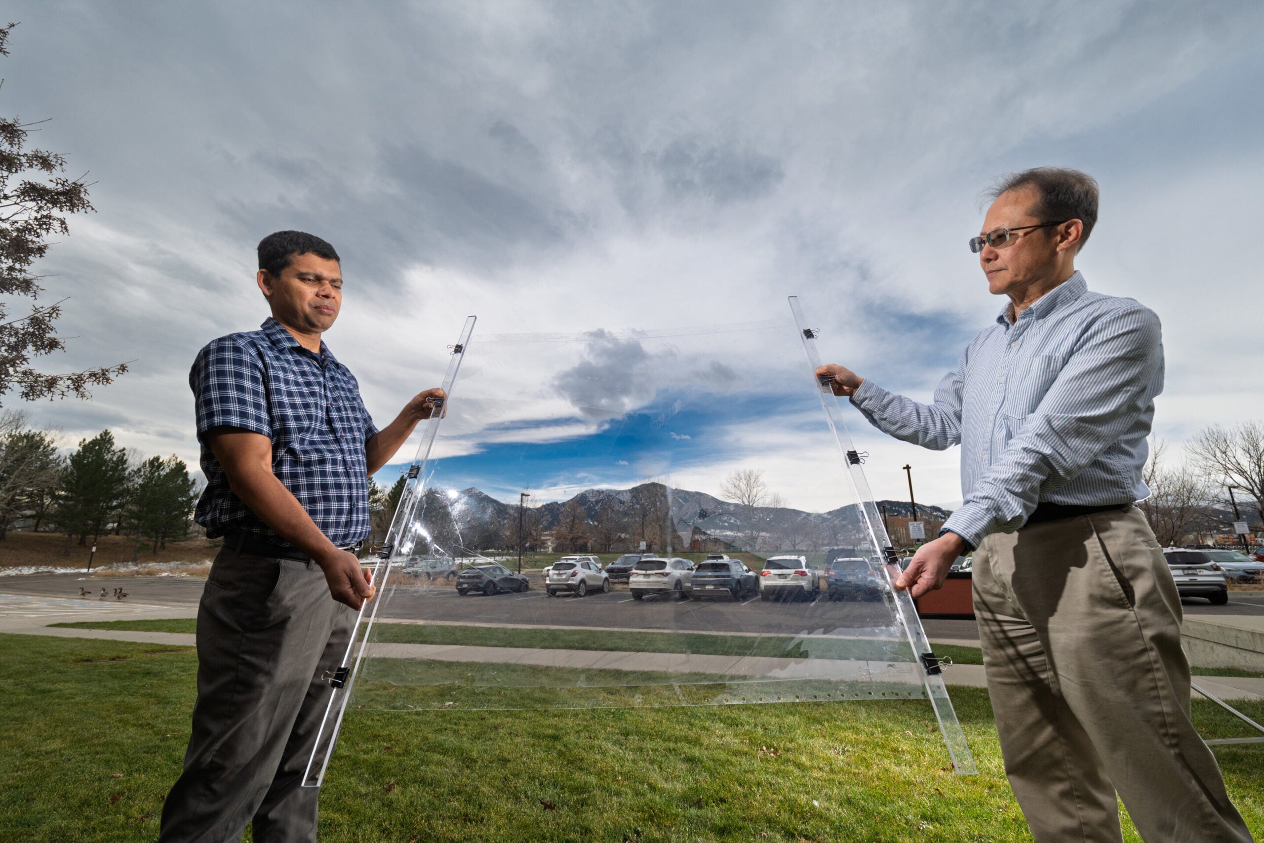 Eldho Abraham, left, and Taewoo Lee, right, hold up a thin sheet of MOCHI affixed to clear plastic.