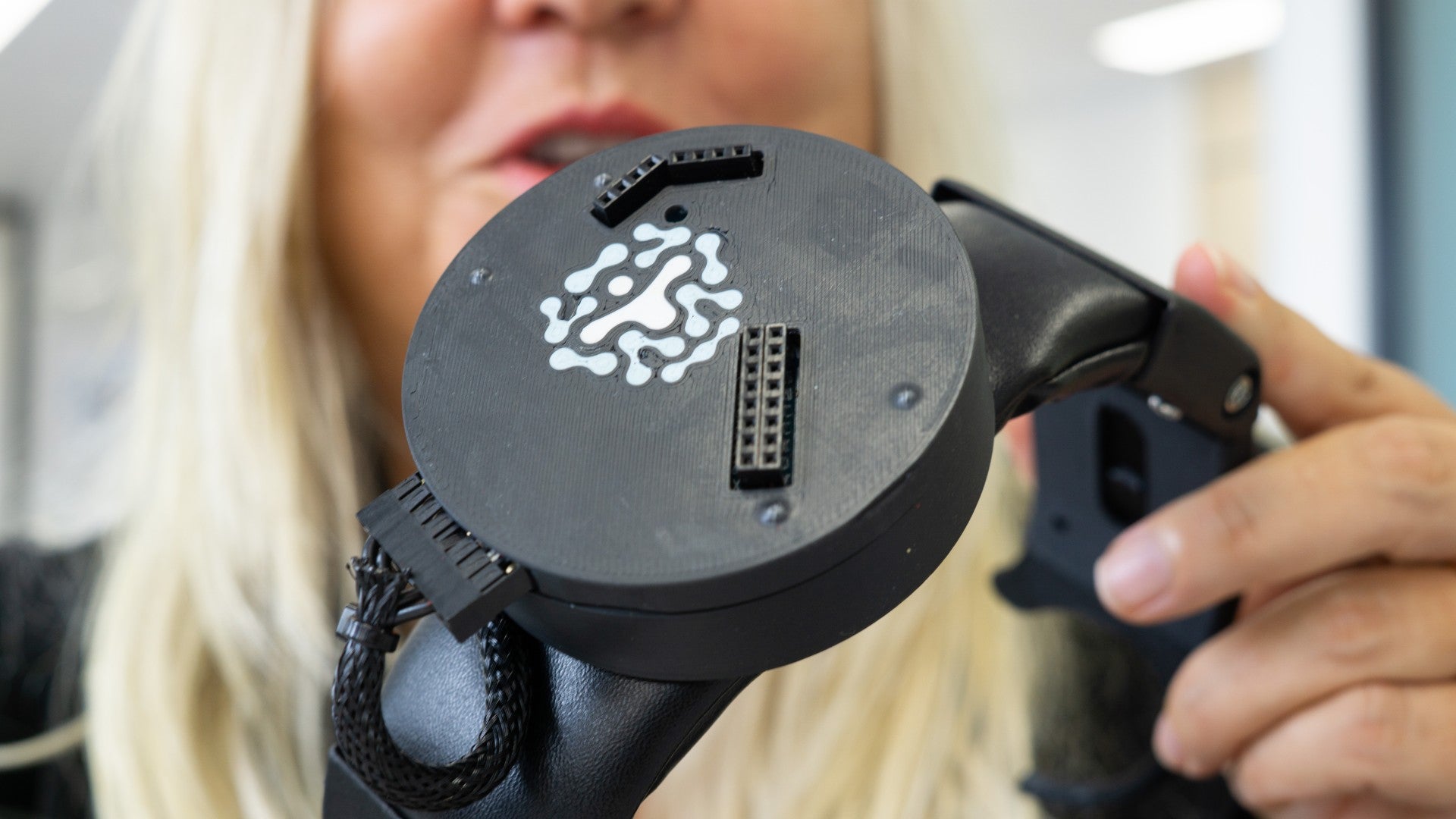 Prof. Sylvia Gustin holds the PainWaive headset. 
