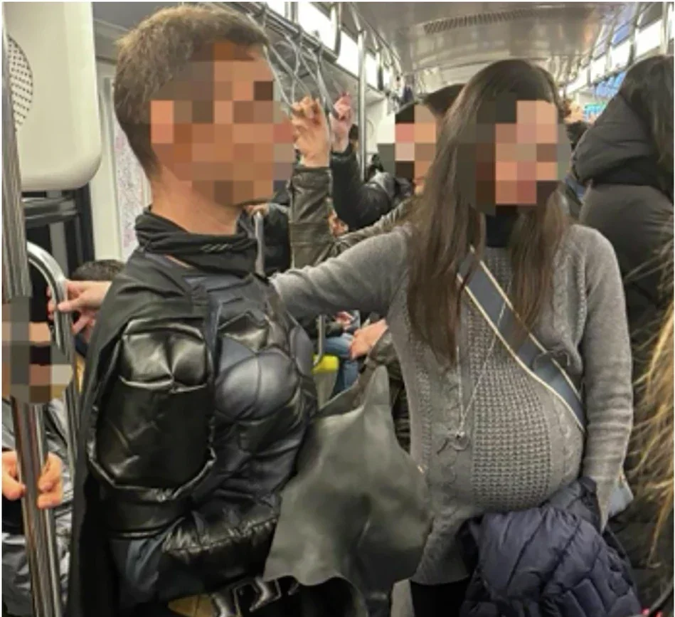 An example of the experimental setting, with Batman and a woman simulating pregnancy stand in a crowded metro.