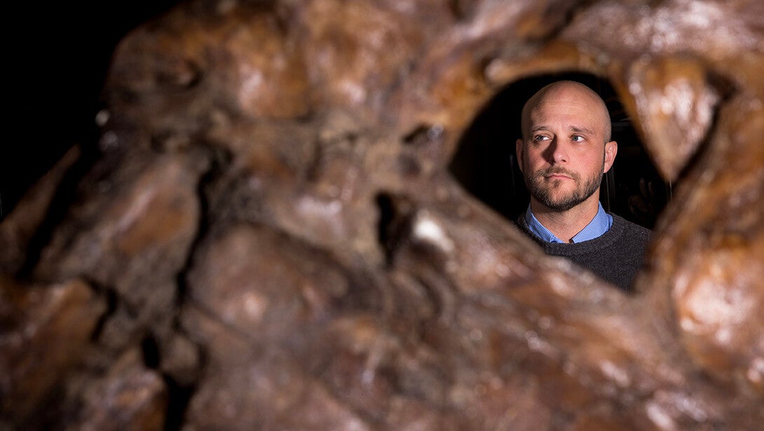 Ashley Poust, Voorhies Endowed Curator of Vertebrate Paleontology for the University of Nebraska State Museum, stands behind a cast of the upper jaw of a Tyrannosaurus rex, one of the largest specimens known.
