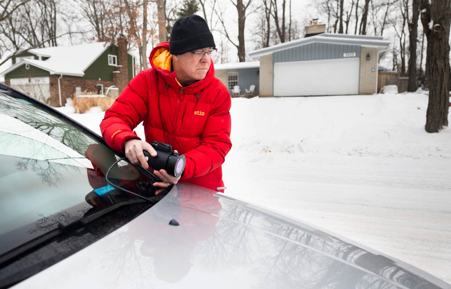 Nilton Renno mounts the infrared sensor onto his car, to test how well it performs on a snow-covered, residential road.