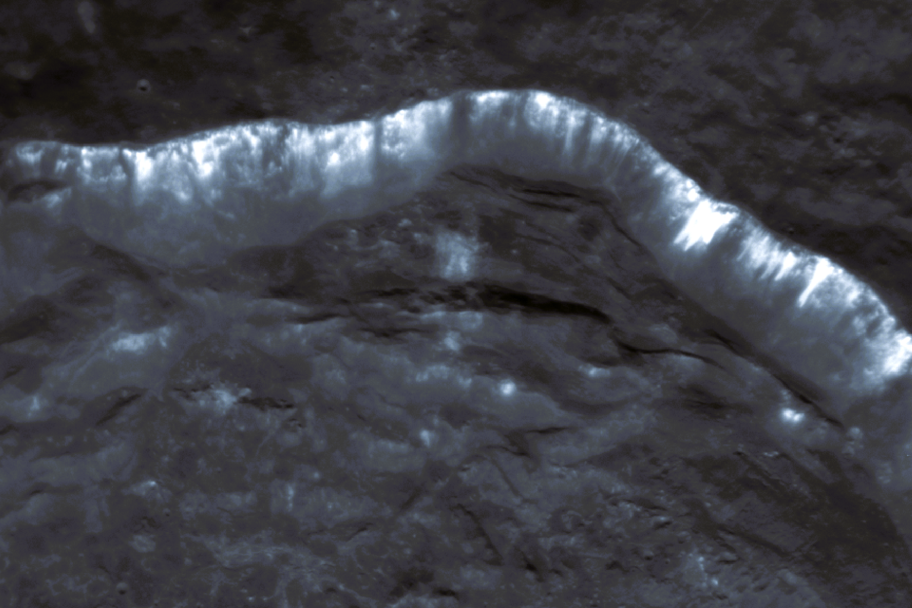 Image of the streaks or “lineae” on the slopes of a crater wall on Mercury and the bright hollows from which the streaks originate. The image was taken by MESSENGER on April 10, 2014.