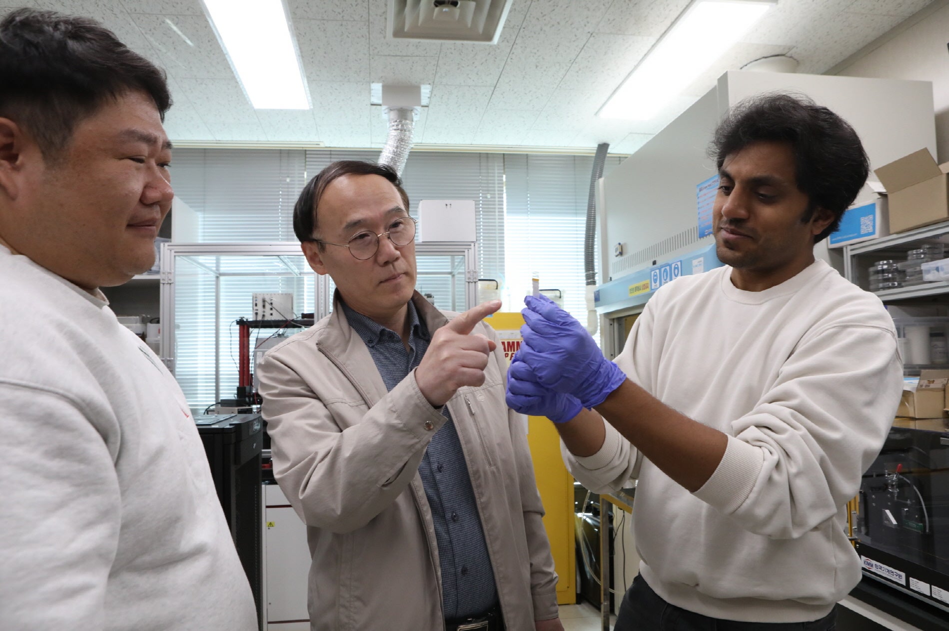 Dr. Shin Hur (center), Principal Researcher at KIMM, examines the noninvasive blood pressure sensor.