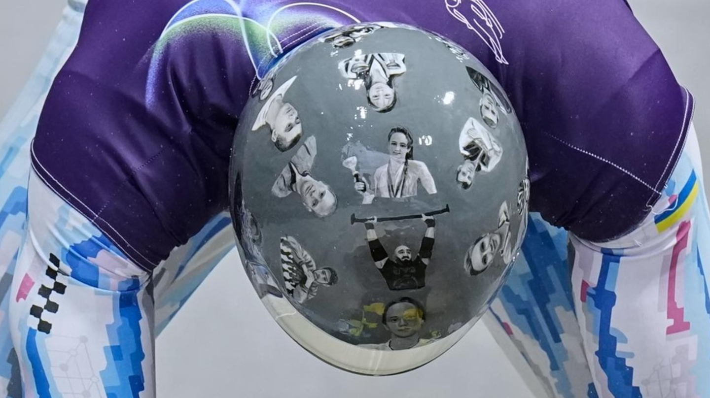A Ukrainian skeleton racer banned from the Olympics receives $200,000 after honoring fallen athletes on his helmet.