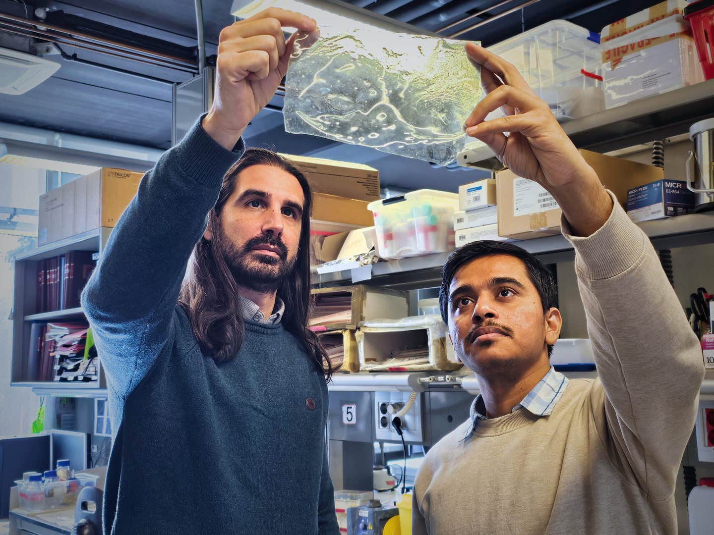 Javier G. Fernández (left) and Akshayakumar Kompa (right) holding a sample of the material at the IBEC laboratories.