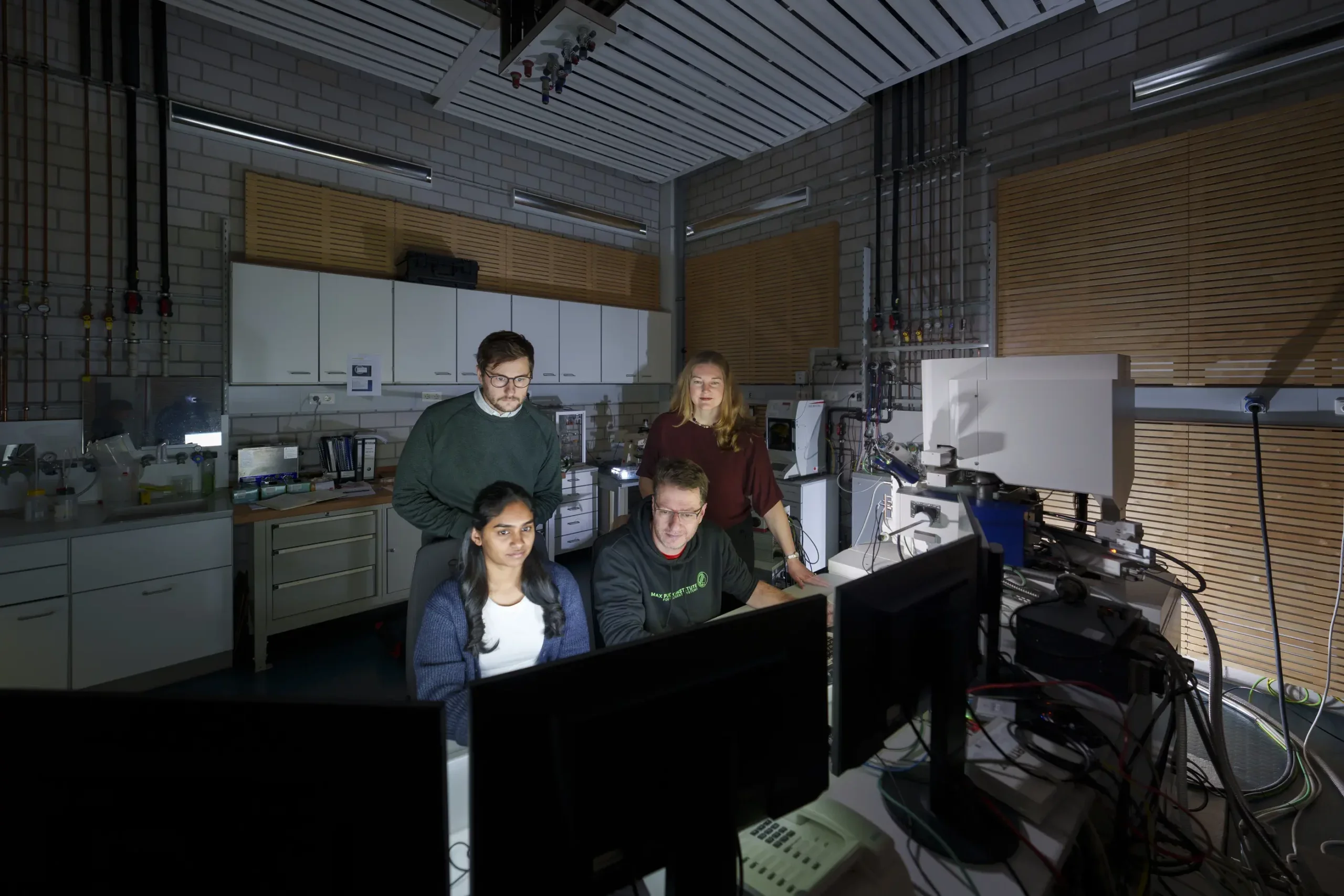 Photograph of four of the paper’s authors observing scanning electron microscopy (SEM) of elephant whisker specimens. Image includes Deepti S. Philip (front left), Dr. Andrew K. Schulz (back left), Prof. Gunther Richter (front right), and Prof. Katherine J. Kuchenbecker (back right).