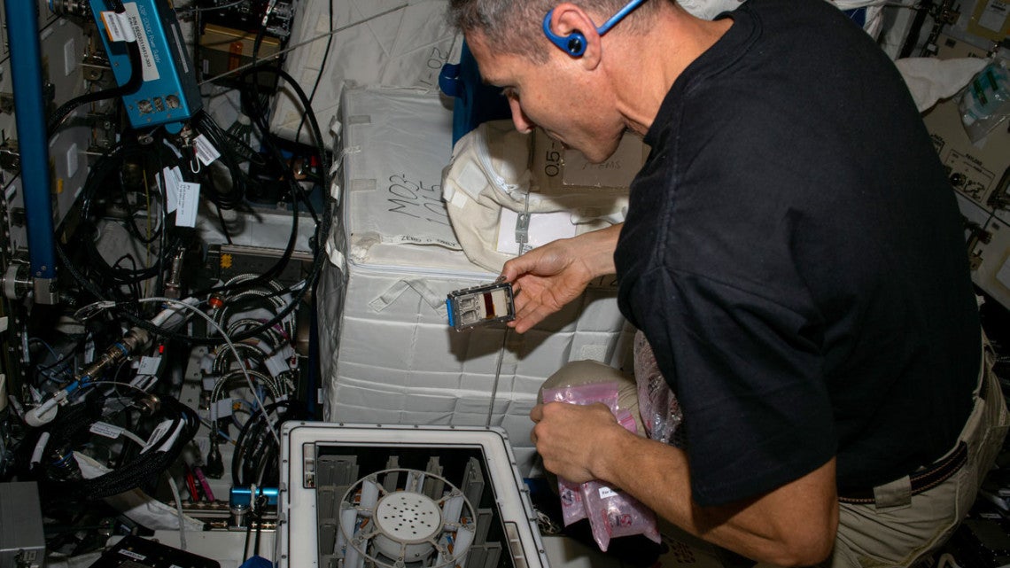 Michael Scott Hopkins performs a microgravity experiment on the International Space Station.