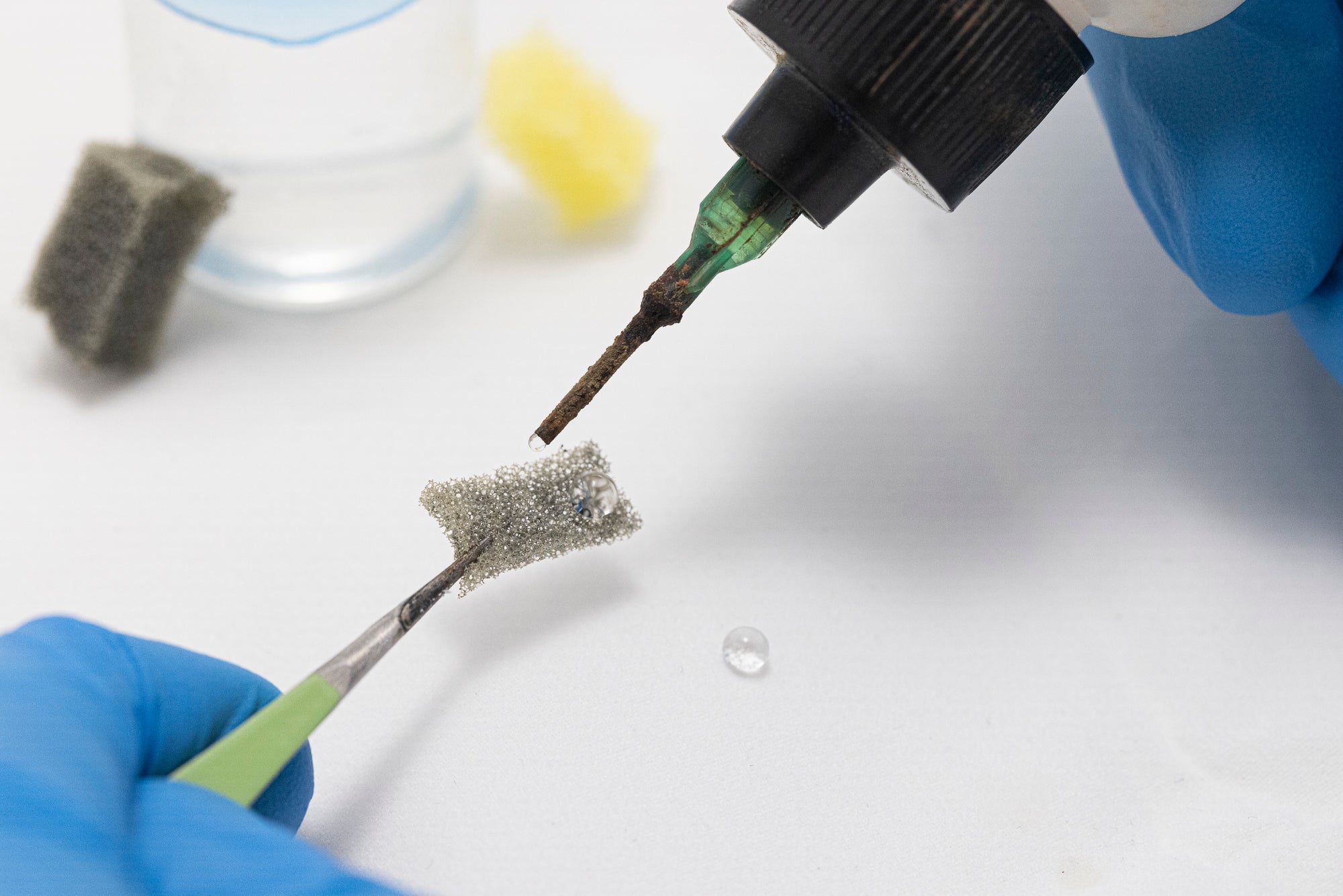 A researcher applies oil to the coated filter material to demonstrate its rapid absorption while remaining water repellent. 