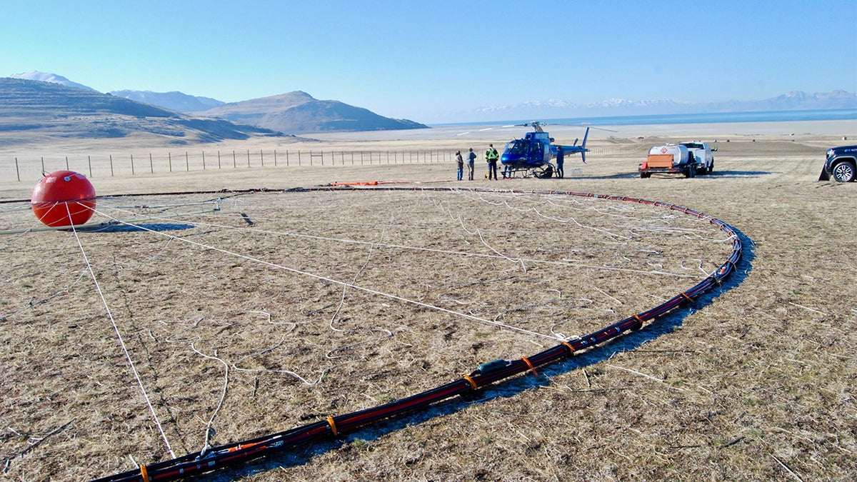 A helicopter crew prepares to fly airborne electromagnetic survey equipment from a staging area on Antelope Island on Feb. 28, 2025.