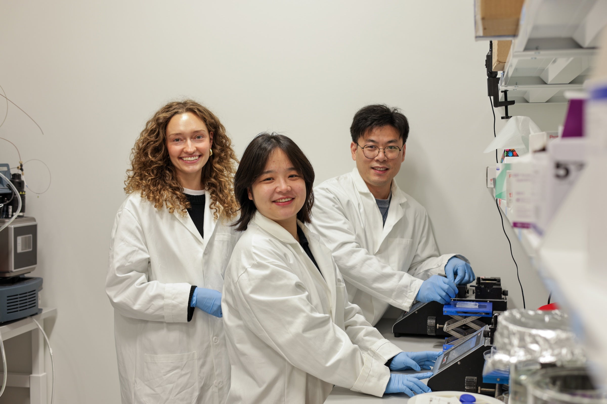 From left: Co-authors Hannah Geisler, Jinjin Wang and Qiangqiang Shi demonstrate the use of a microfluidic mixing device used to create the new nanoparticles. 