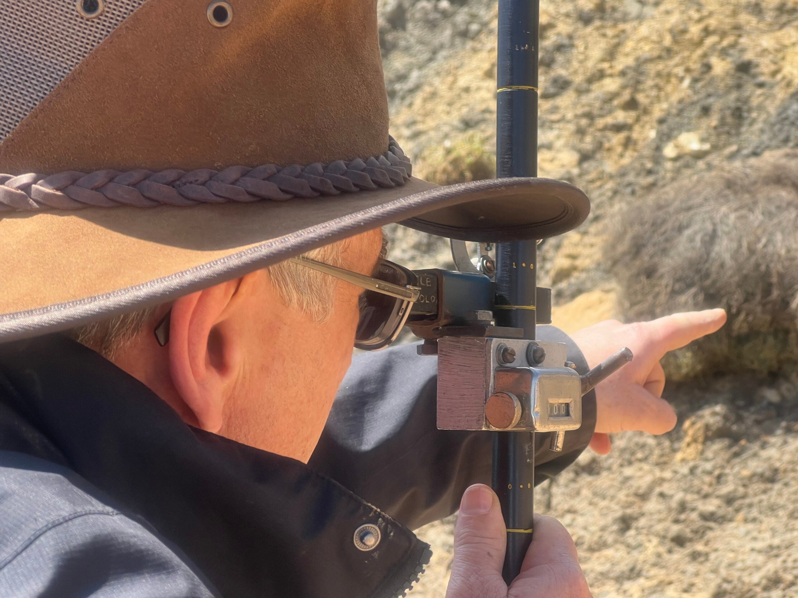 Associate Professor Stephen Gallagher uses a Jacob's staff to measure the rock layers.