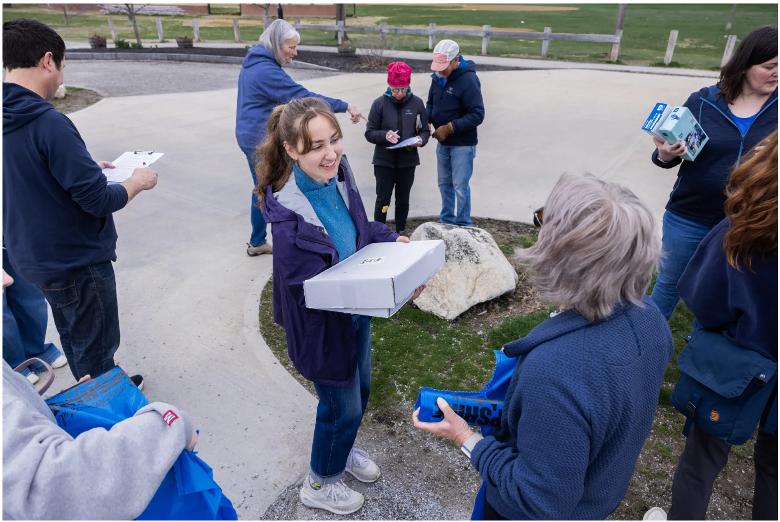 Concord High senior Clover Doperalski passes out collection bags on Saturday, April 18, 2026. Doperralski was part of the organizing team for the Earth Day project around the city.