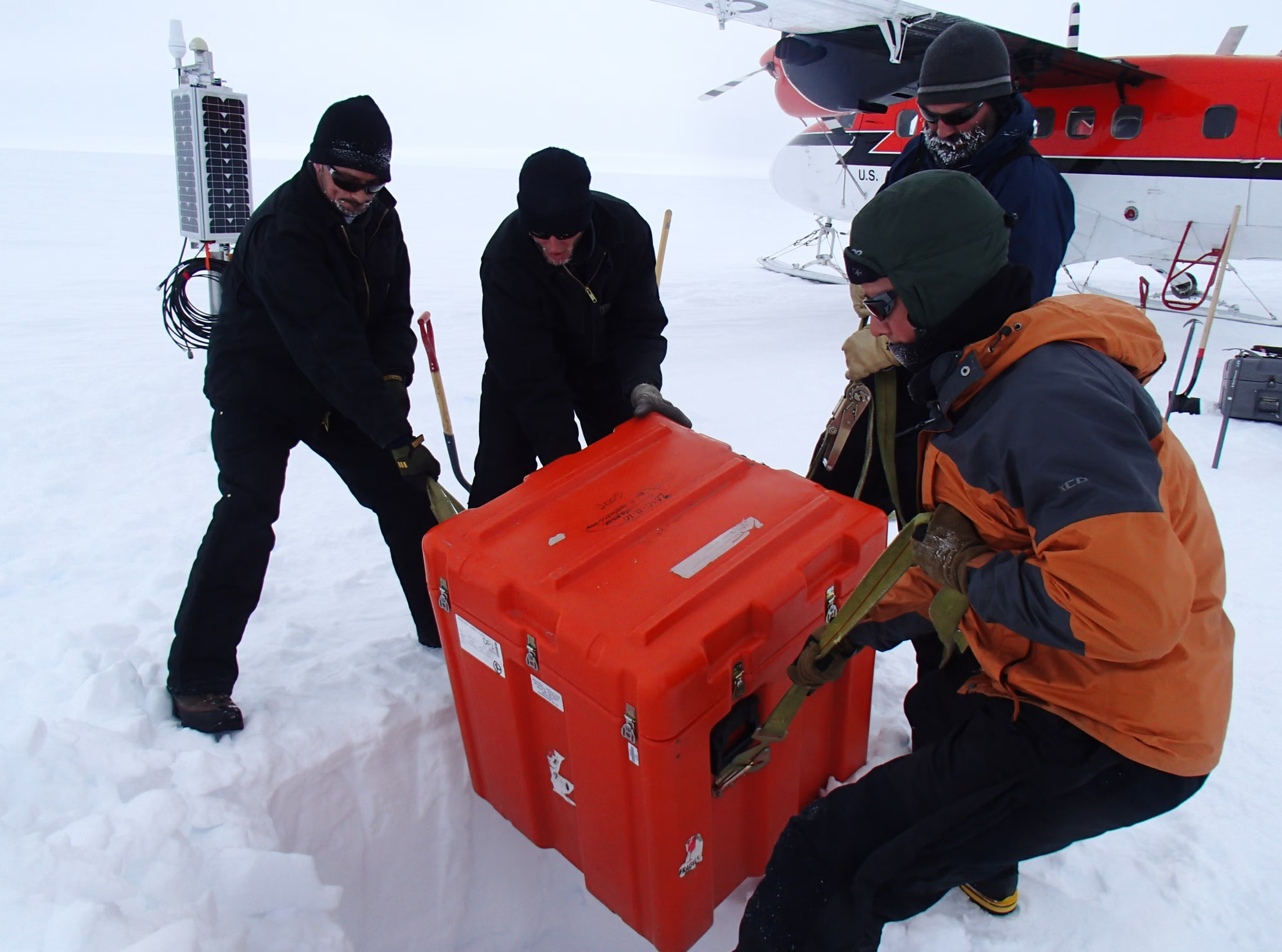 Scientists position seismic instruments at a remote station to probe the depths of the Transantarctic Mountains