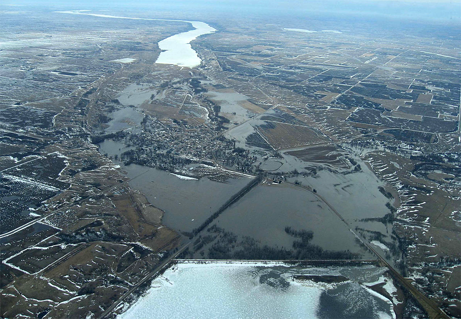 An aerial view captures floodwaters surging through the Traverse Gap—the ancient southern spillway of Glacial Lake Agassiz and the birthplace of the River Warren.