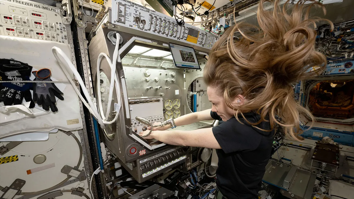 NASA astronaut Nichole Ayers, an Expedition 73 flight engineer, works to install the Ring Sheared Drop module in a science glovebox aboard the International Space Station.