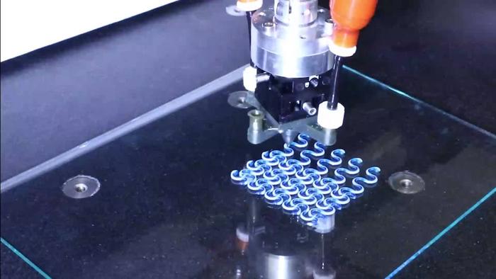 A lattice of active and passive filaments being printed via rotational multimaterial 3D printing. 
