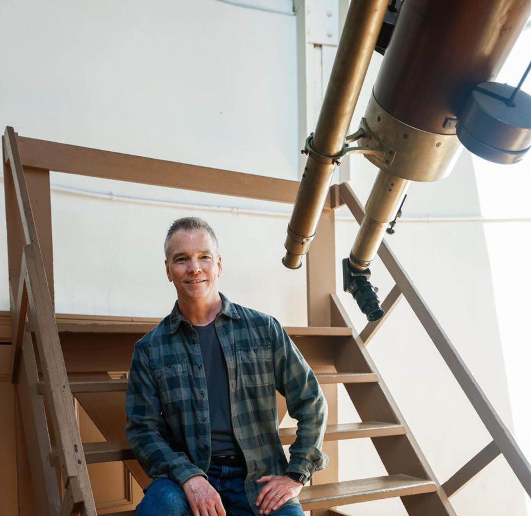 Paul Smith, pictured with the Cincinnati Observatory's historic telescope, is using geology and physics tools to study exoplanets light years from Earth.